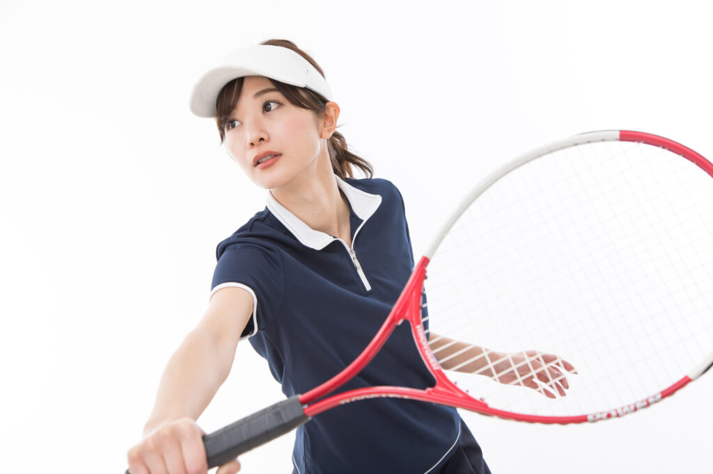 テニスに打ち込む女性