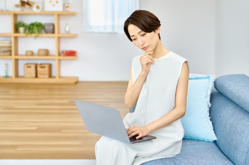パソコンの前で悩む女性